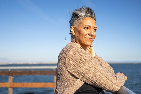 woman looking out onto the water from a boardwalk